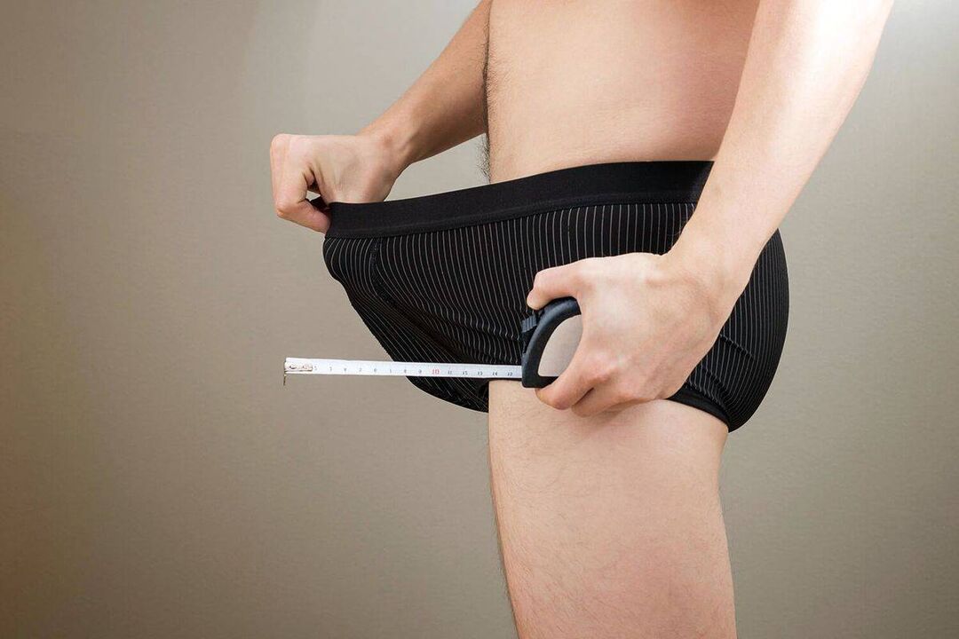 a man looks inside his underwear and wants to enlarge his penis